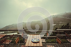 Misty mountians over cafe terrace with breakfast table. Natural landscape and local outdoor restaurant without tourists photo