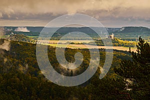 Misty rainy morning landscape with the sand rocky montains in Bohemian Saxon Switzerland in autumn colors