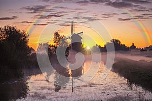 Misty and rainy windmill warm sunrise