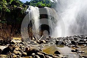 Misty rocky waterfall captured low angle.