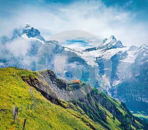 Misty summer view of Wetterhorn peaks . Picturesque morning scene of Swiss Bernese Alps, Switzerland