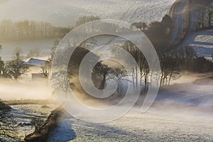 Misty sunrise over the Devonshire fields with trees in view, Brentor , Devon , UK