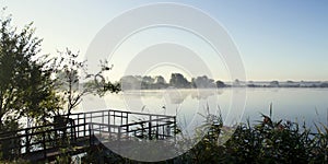 Misty sunrise over a lake summer morning