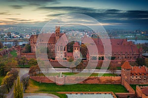 Misty sunrise over the Malbork castle and Nogat river in Poland photo