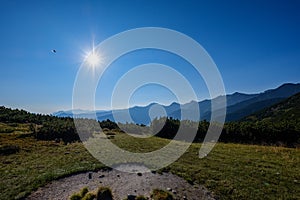 Hmlistý východ slnka v slovenských Tatrách so svetelnými pruhmi v