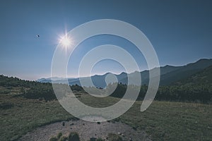 misty sunrise in Slovakian Tatra mountains with light lanes in fog over dark forest. autumn in hiking trails - vintage old film