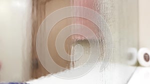 Misty wet mirror over a bathroom shelf, perspective view, blurred closeup