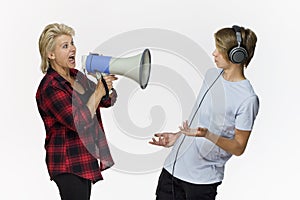 Misunderstandings in family. Angry mother with megaphone talking to her male teenager
