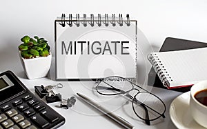 MITIGATE concept written on a small blackboard on easel