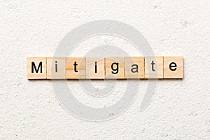 mitigate word written on wood block. mitigate text on table, concept