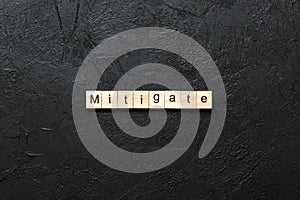 mitigate word written on wood block. mitigate text on table, concept photo