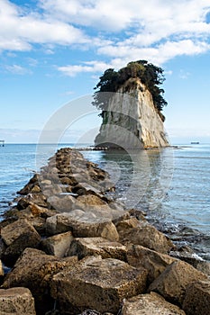 Mitsukejima diamond shaped island with trees on top of the rock, view with stone pier, on Noto Peninsula, Japan.