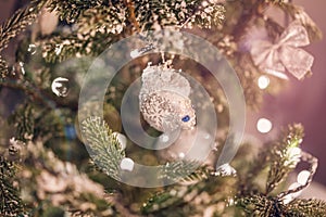 Mitten with snowflake hanging on branch of Christmas tree