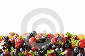 Mix berries and fruits on white background. Ripe blackberries, strawberries, blackcurrants and plums. Top view. Background berries