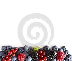 Mix berries isolated on a white background. Fresh blueberries, raspberries, red currants, blackberries, gooseberries.