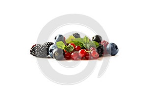 Mix berries isolated on a white. Ripe blueberries, blackberries, raspberries, gooseberries, red and blackcurrants with mint. Berri