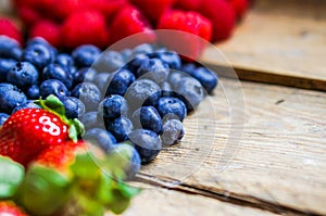Mix of berries on rustic wooden background