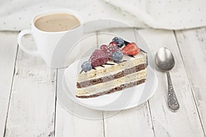 Mix berry cheese cake on white plate on wood background