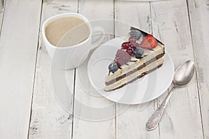Mix berry cheese cake on white plate on wood background