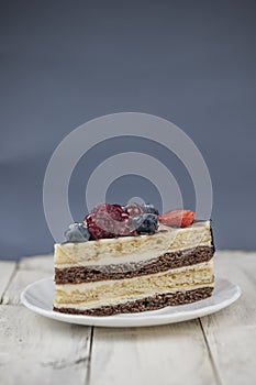 Mix berry cheese cake on white plate on wood background