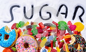 Mix of candies donuts and sugar in writing