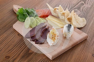 Mix cheese with tomato, cucumber and pita bread served in wooden board isolated on table side view of arabic food