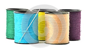 Mix of colored thread spool with needle isolated on white background