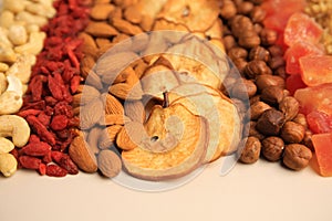 Mix of delicious dried nuts and fruits on beige background, closeup