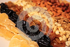 Mix of delicious dried nuts and fruits on beige background, closeup