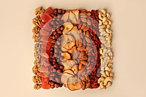 Mix of delicious dried nuts and fruits on beige background, flat lay