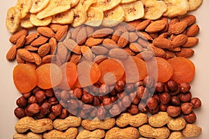 Mix of delicious dried nuts and fruits on beige background, flat lay