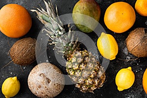 Mix of different fruits, on black dark stone table background, top view flat lay