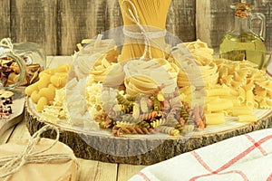 A mix of different types of pasta on a wooden background