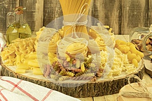 A mix of different types of pasta on a wooden background