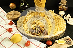 A mix of different types of pasta on a wooden background