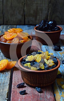 Mix of different varieties of dried fruits on wooden background - dates, apricots, prunes, raisins. Organic healthy food. Excellen