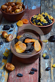 Mix of different varieties of dried fruits on wooden background - dates, apricots, prunes, raisins. Organic healthy food. Excellen