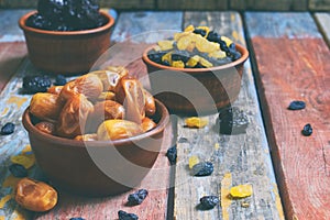 Mix of different varieties of dried fruits on wooden background - dates, apricots, prunes, raisins. Organic healthy food. Excellen