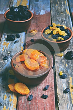 Mix of different varieties of dried fruits on wooden background - dates, apricots, prunes, raisins. Organic healthy food. Excellen