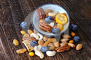 Mix dried fruit and nuts on a wooden background.