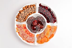 Mix of dried fruits and nuts. Apricot, raisin, cranberry, dates fruit. Isolated on a white background. Space for text or design