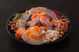 Mix of dried fruits and nuts on a black table