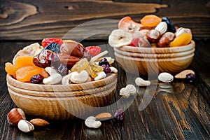 Mix of dried fruits and nuts on a dark wood background with copy space. Symbols of judaic holiday Tu Bishvat.