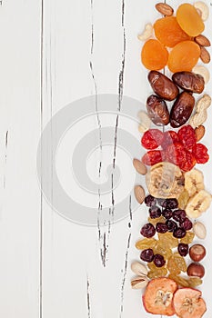 Mix of dried fruits and nuts on a white vintage wood background with copy space. Top view. Symbols of judaic holiday Tu Bishvat.