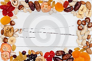 Mix of dried fruits and nuts on a white vintage wood background with copy space. Top view. Symbols of judaic holiday Tu Bishvat. photo