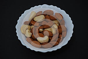 Mix dry fruits cashew nuts and almonds in the bowl on black background