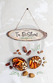 Mix of dry fruits and nuts and a plate on a light background. Tu Bishvat in English and Heb