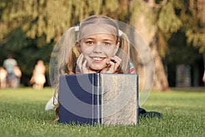 Mix of fantasy and reality. Happy girl read fantasy book on green grass. Little child enjoy fantasy story. Concept of