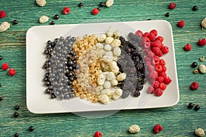 Mix of fresh berries in on plate on wooden background. Antioxidants, detox diet, organic fruits.