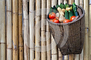 Mix fresh organic vegetables and fruits in wooden basket .